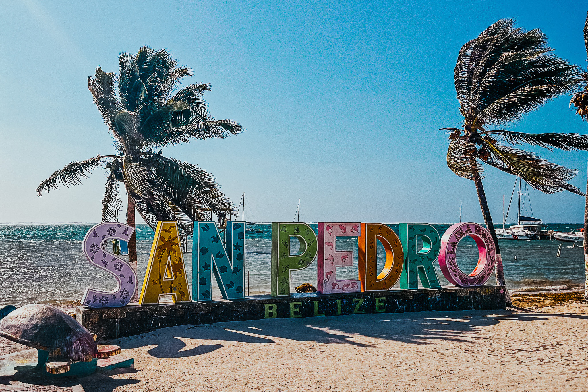 Letters San Pedro op het strand voor de zee met palmbomen