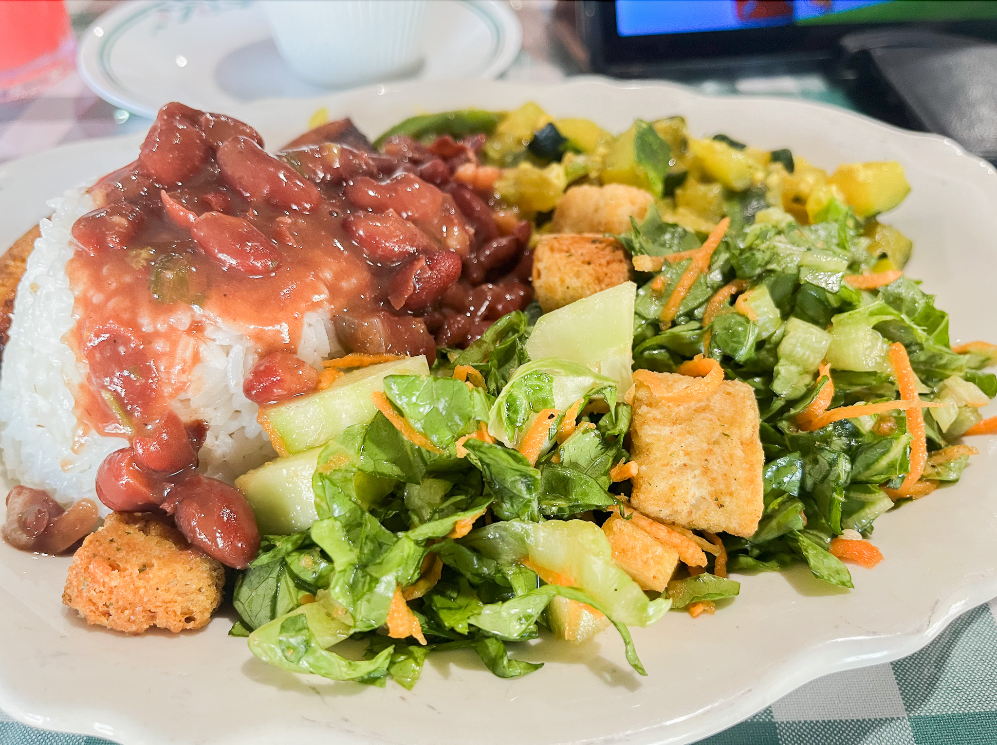 Belizaans gerecht met witte rijst, bonen en een salade met croutons.